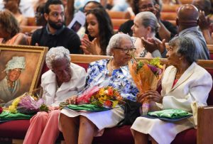 WASHINGTON, DC - JUNE 18: Centenarians (L-R) Ruth Chatman Hammett, Gladys Ware Butler and Bernice Grimes Underwood and a portrait of their friend Leona Barnes, who died last month, receive flowers during their 100th birthday celebration at the Zion Baptist Church on June 18, 2016 in Washington, DC. (Photo by Jonathan Newton / The Washington Post via Getty Images)