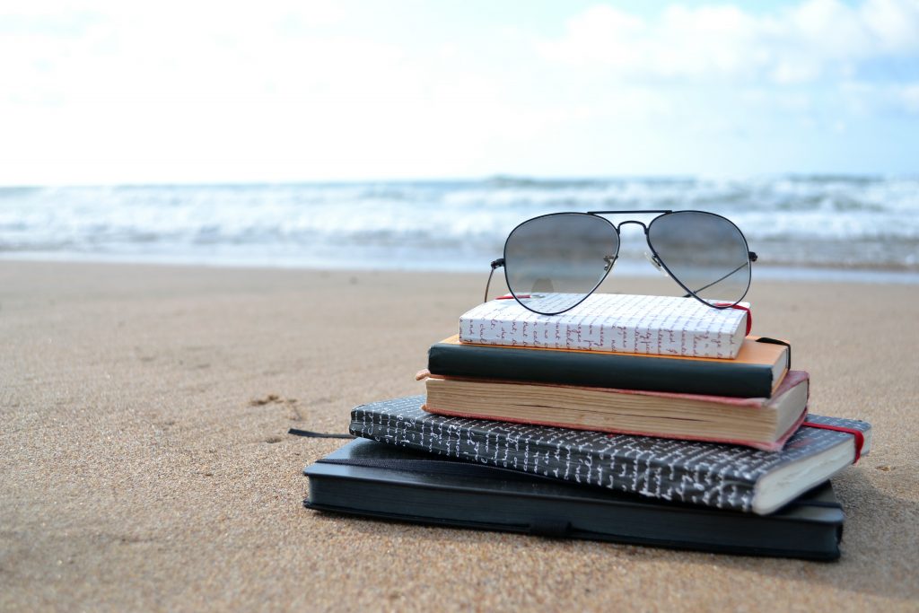 Summer holiday setting with book on beach