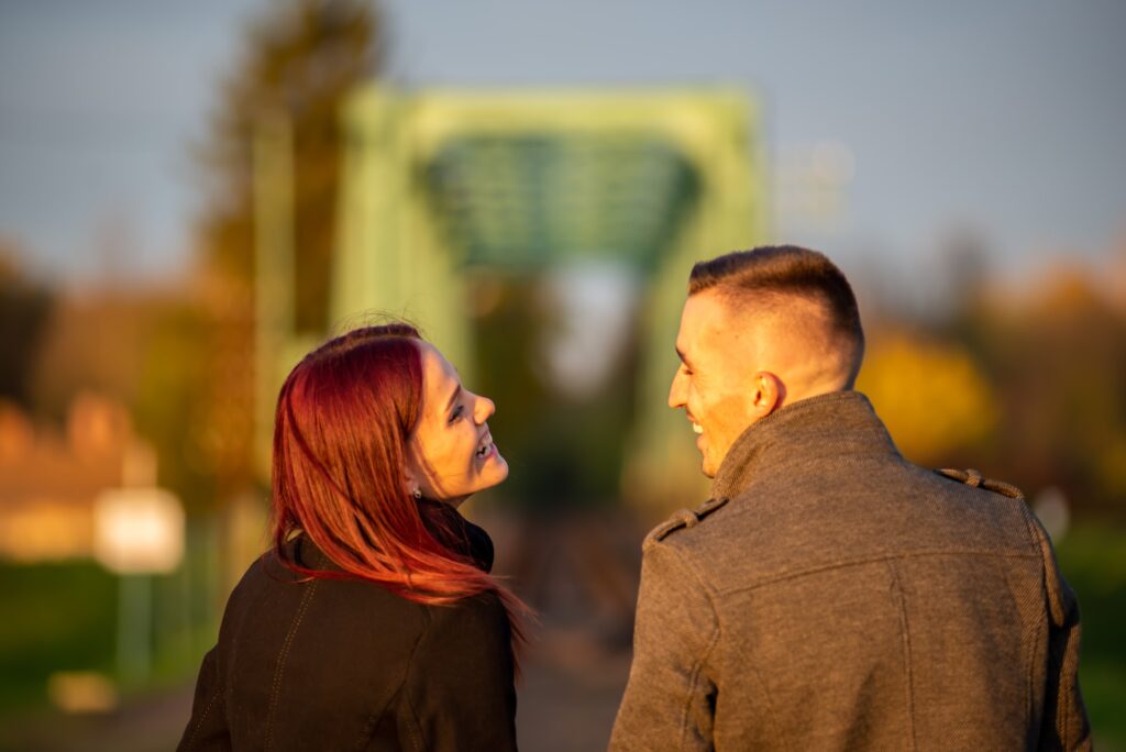 man and woman looking at each other outside at sunset