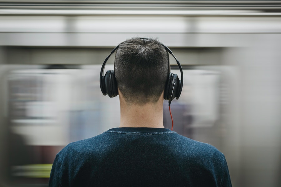 for an article about autism, a man wears headphones in front of a blurred background