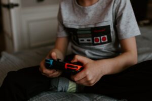 A kid plays a game with a Nintendo Switch controller