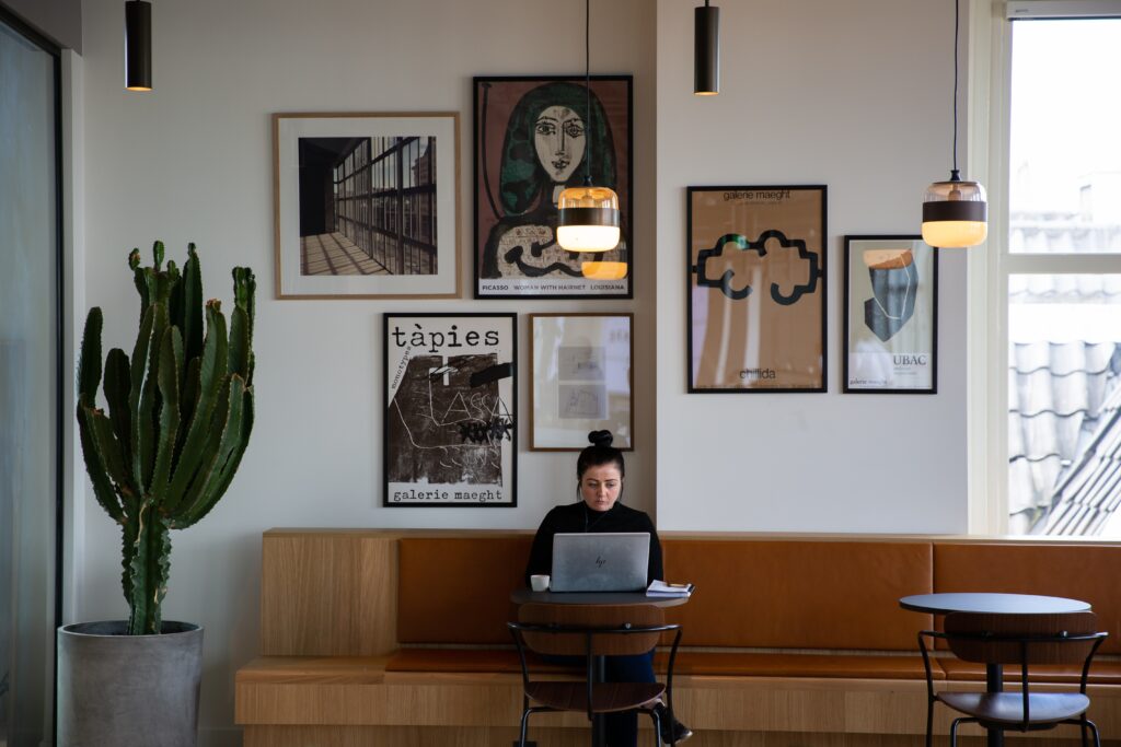 Woman working on a laptop in a coffee shop.
