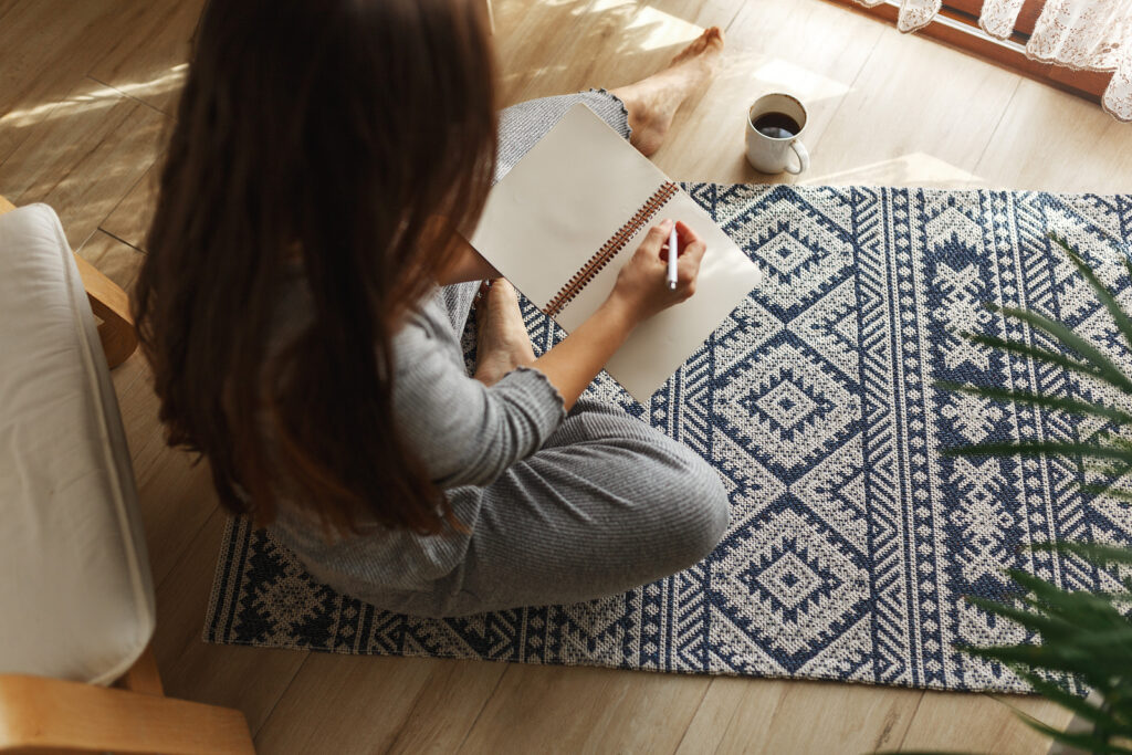 Woman sitting on floor journaling