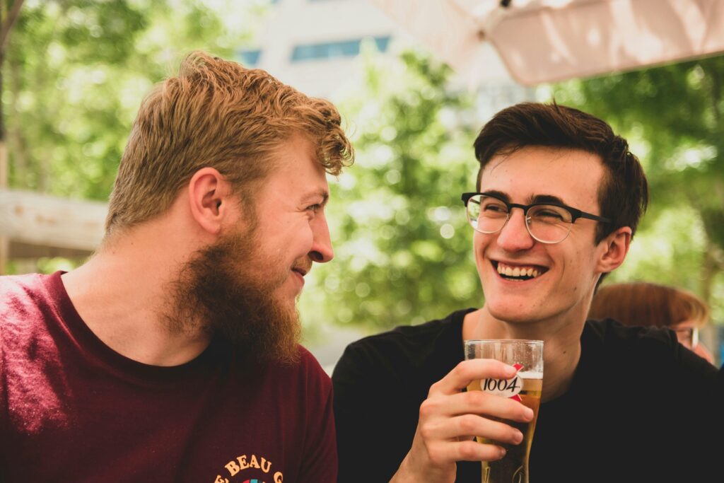 Two smiling guys out for a drink.